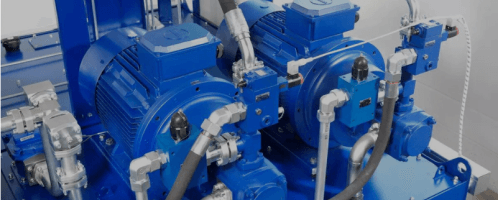 Industrial hydraulic pumps in blue power unit setup