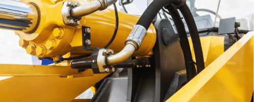 Close-up of hydraulic cylinders and components on yellow machinery